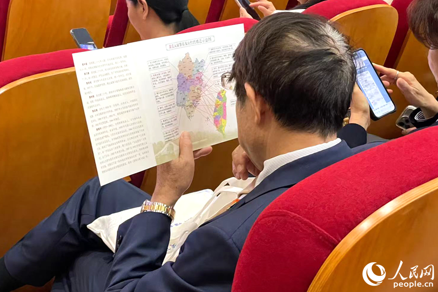 一位嘉賓認(rèn)真端詳姓氏入閩及遷臺(tái)示意圖。人民網(wǎng)記者 林盈攝