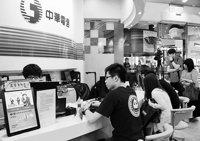 臺北中華電信營業廳里,顧客在咨詢4G業務。 臺北中華電信營業廳里,顧客在咨詢4G業務。