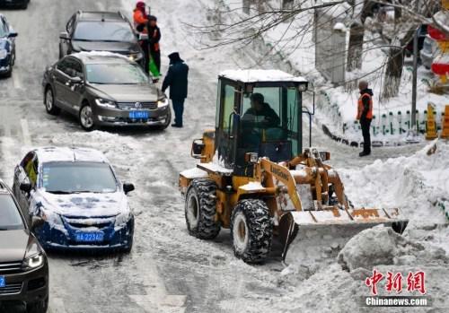 在烏魯木齊市區(qū),大型機械設(shè)備出動清理道路上的積雪。 中新社記者 劉新 攝