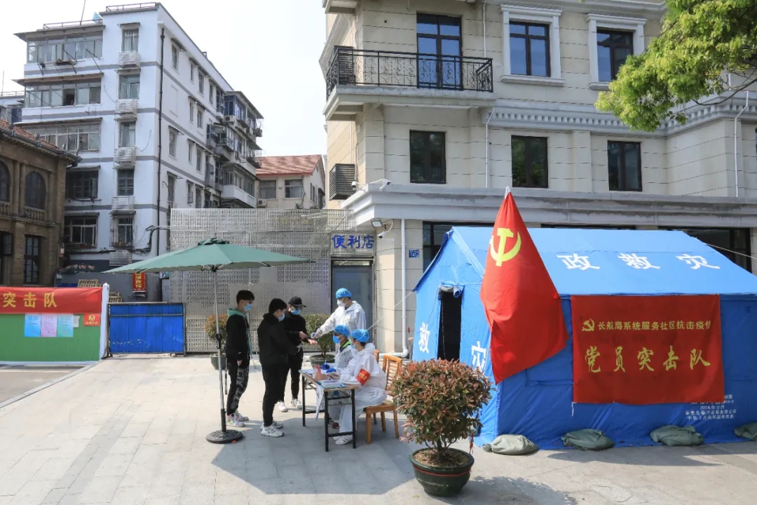 黨員突擊隊在小區防控點為出入群眾測量體溫,記錄信息。
